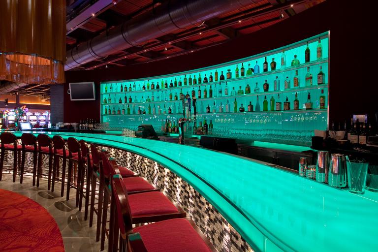 A curved bar with ample seating and liquor bottles
