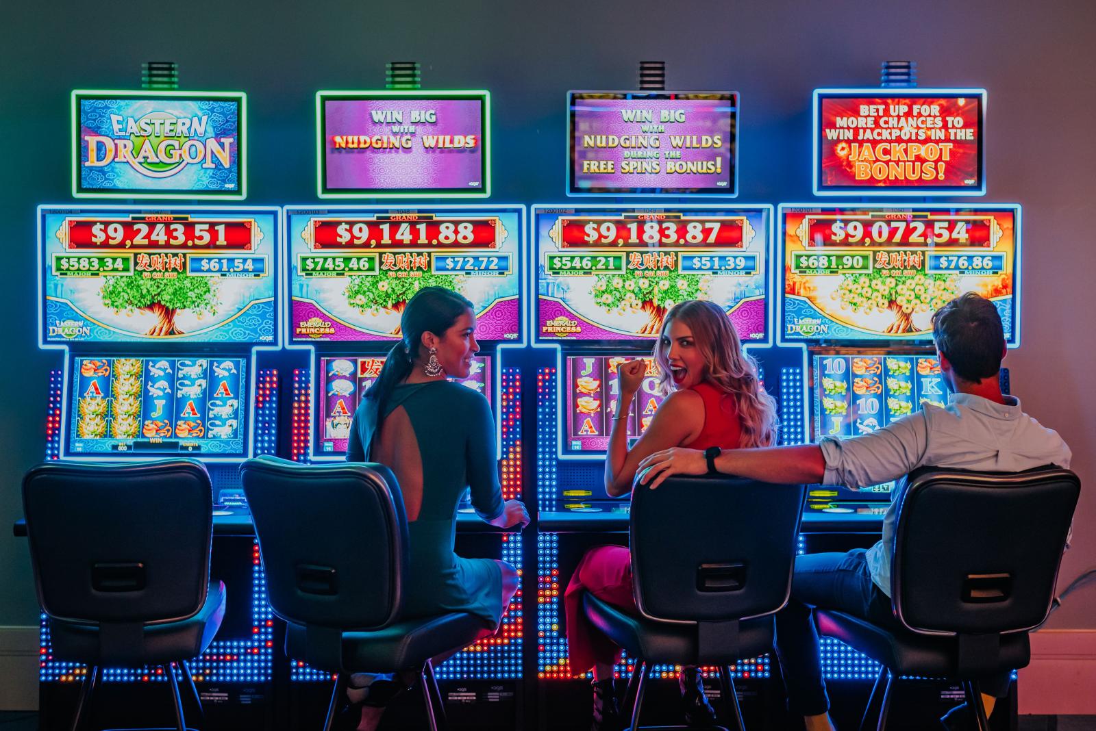 Three people playing slots
