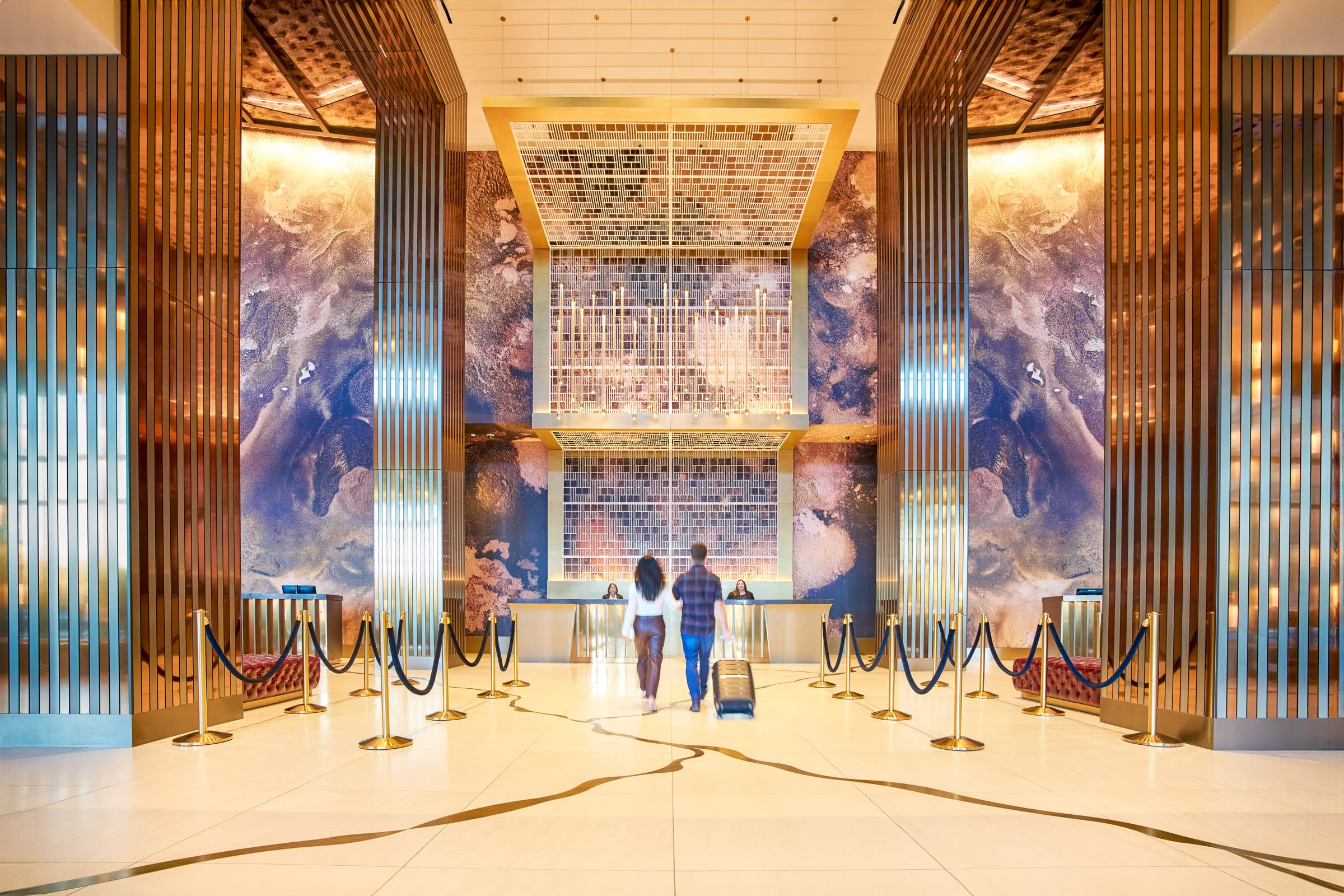 Long shot of an elegant hotel lobby where a couple is checking in