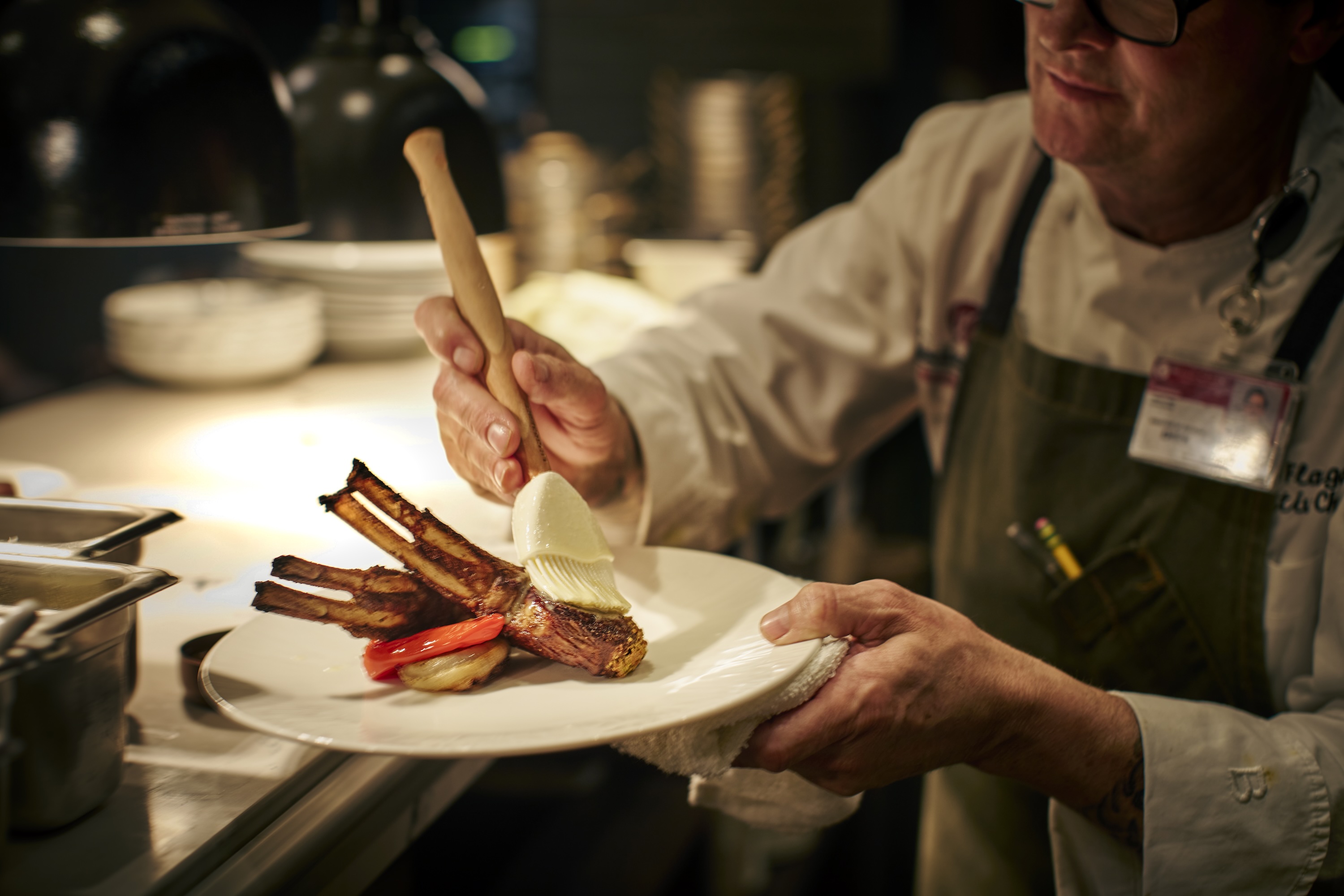 A chef preparing lamb chops.
