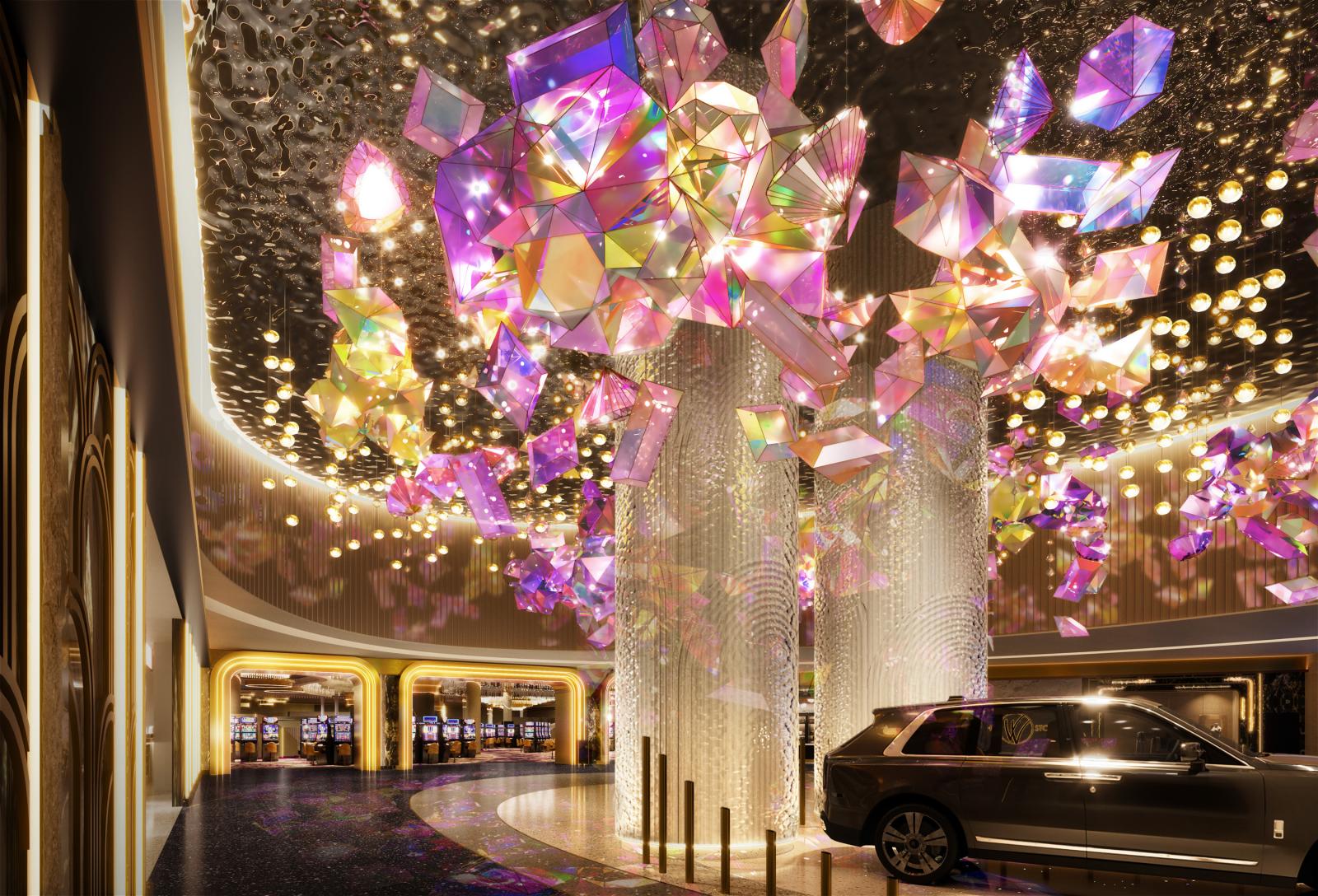 A glowing lobby decorated in gold with iridescent gemstones suspended from the ceiling.