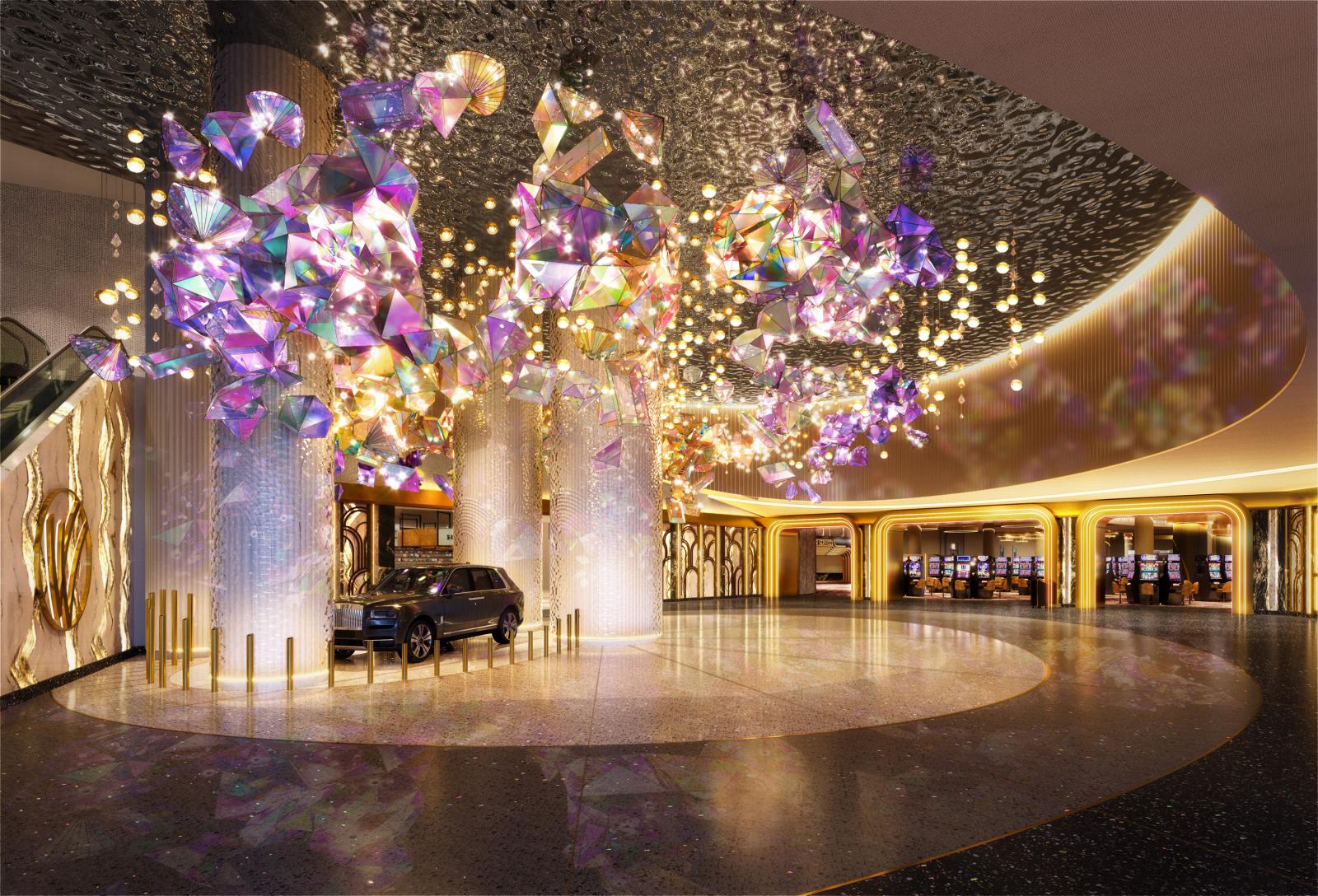 A glowing lobby decorated in gold with iridescent gemstones suspended from the ceiling.