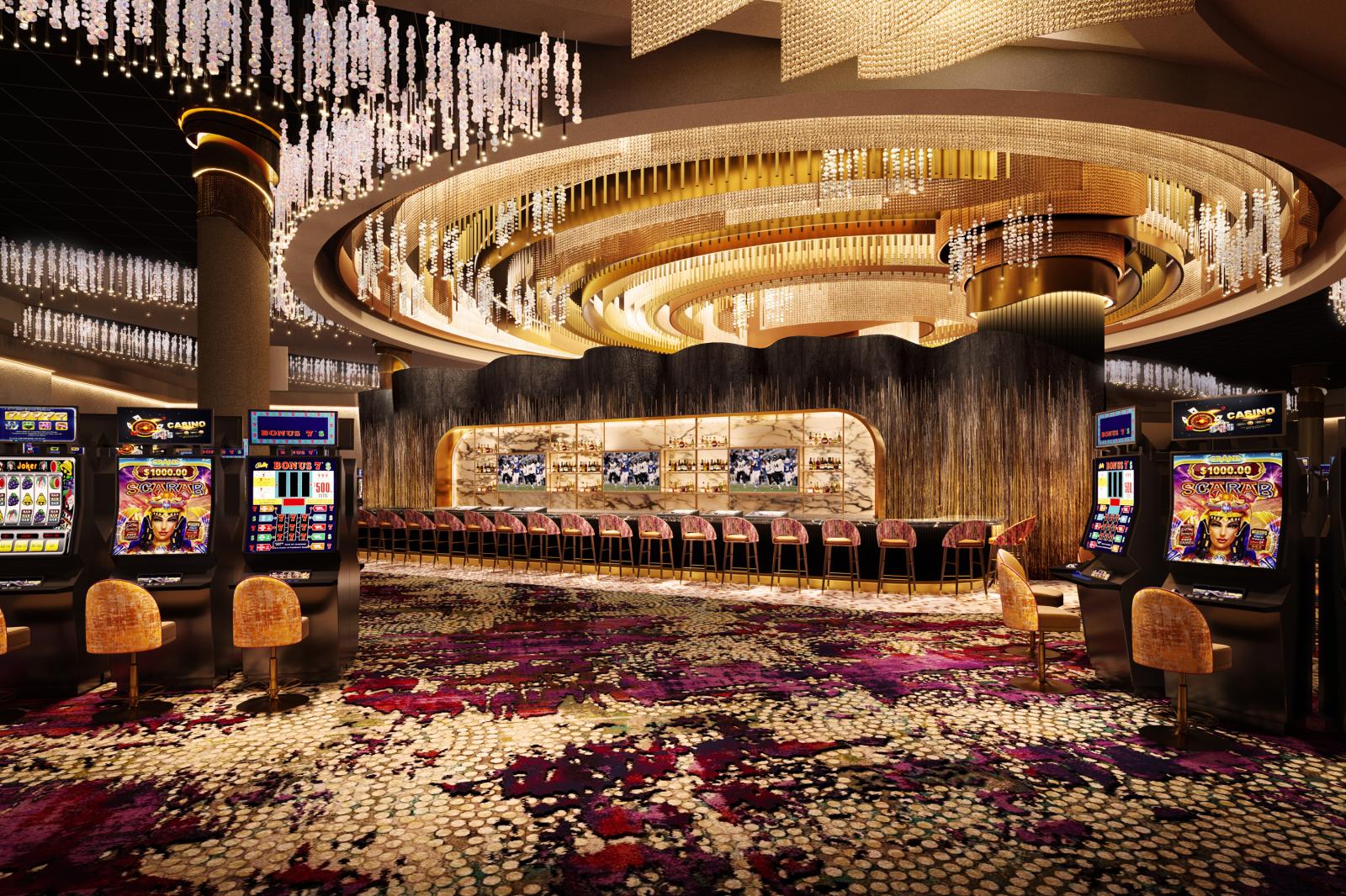 View of casino bar area decorated in magenta and gold with sparkling light fixtures and circular ceiling adornments