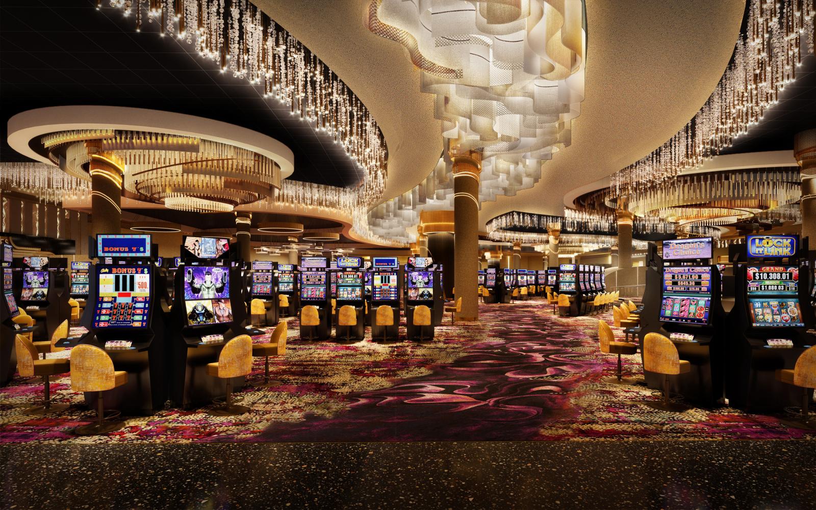 View of the casino floor with clusters of slot machines, flowing, sparkling lighting, and a gold and magenta swirling carpet. 