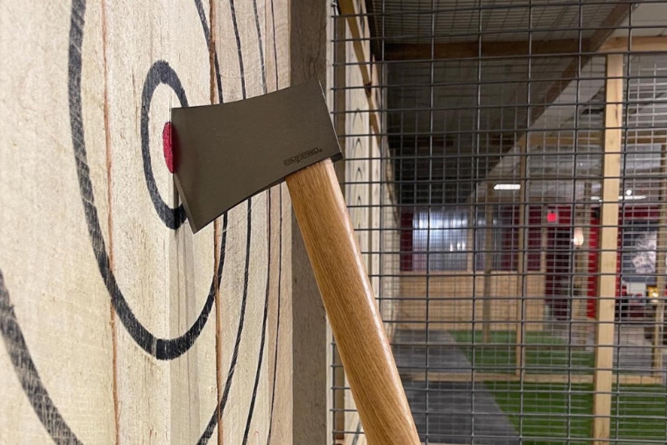 An axe embedded into the bullseye of a wooden target