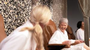 Image of three women sitting in spa chairs with spa robes on