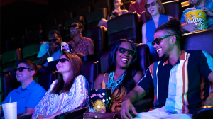 Moviegoers wearing 3D glasses, enjoying popcorn
