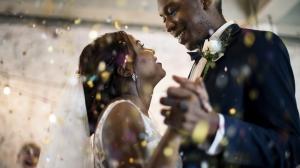 A bride and groom dance among sparkling confetti